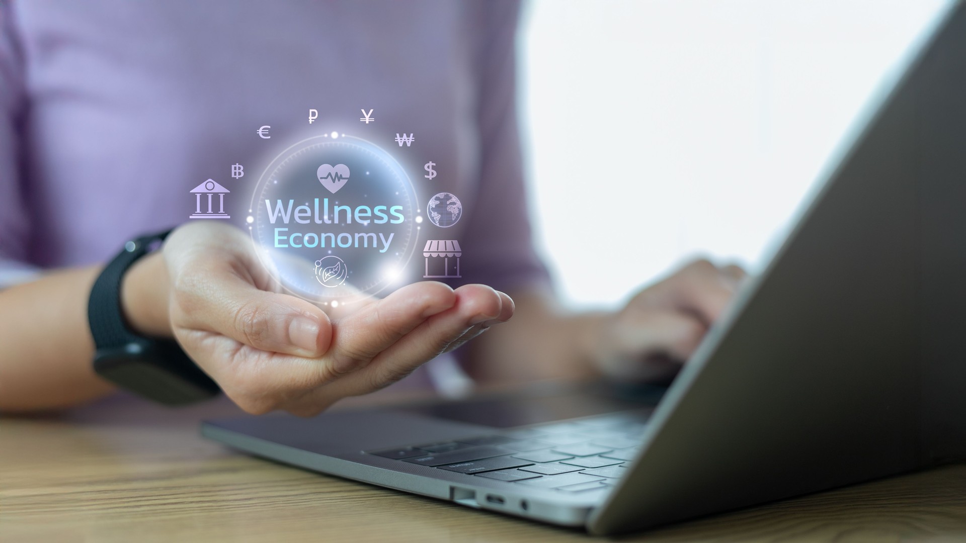 Hand holding virtual hologram of Wellness Economy icon with financial, health, and global business symbols. Concept of digital health economy, fintech wellness, and mindful lifestyle commerce.